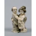 A Japanese carved ivory netsuke in form of a lady and gentleman embracing, base signed, 2.25in h.