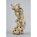 A Japanese carved ivory figure of an Alchemist, he standing on seaweed rock and being attacked by