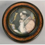 A 19c horn and tortoiseshell carved circular box and cover with a watercolour insert of a priest