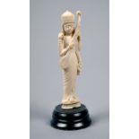 A carved ivory figure of a lady standing playing a string instrument, she being a god with four