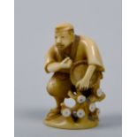 A Japanese carved and stained ivory netsuke in the form of a farmer, base signed, 2in h,