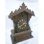 An old cuckoo mantel clock with circular dial in carved wood and ebonised traditional case (af)