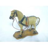 An old skin covered toy horse on wooden four-wheel stand,