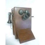 An early mahogany cased wall mounted telephone with twin bells and side ear piece