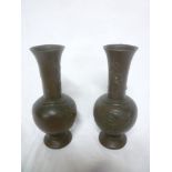 A pair of Japanese bronze tapered vases decorated in relief with birds and flowers,