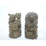 A pair of Eastern carved wood figures of seated characters,