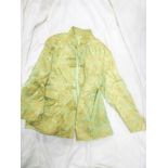 A Chinese silk jacket with embroidered landscape decoration on green ground