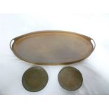 A Newlyn copper oval two-handled tea tray with beaten decoration and two Newlyn copper circular