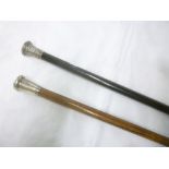 A gentleman's ebonised walking cane with silver mounted top and one other silver mounted walking