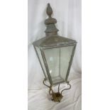 An old copper square tapered street lantern top with glass panels and iron scroll mounts