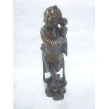An Eastern carved wood figure of a deity holding a vase,