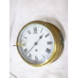 A brass ships bulk head wall clock with enamelled circular dial in brass cylindrical case