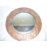 A Newlyn -style copper framed circular wall mirror decorated with dolphins and scallops,