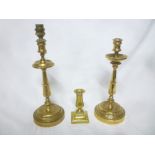 A pair of bronze tapered candlesticks with circular spreading bases and one other 19th century