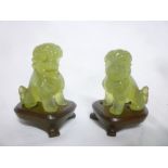 A pair of Eastern jade miniature figures of seated temple dogs,