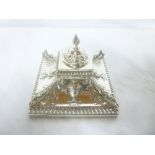 An Edward VII silver square desk stand with central inkwell enclosed by a hinged cover flanked by