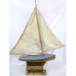 An old wooden model pond yacht with weighted keel and linen sails,