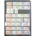 A folder album containing a 1935 silver Jubilee omnibus collection of stamps,