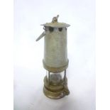 An old painted steel and brass mounted bonetted miner's lamp