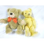 An old plush covered teddy bear with articulate limbs and a modern Steiff plush covered teddy bear