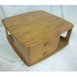 A 1960's Ercol light elm square Pandora's-style coffee table with end drawers on casters