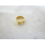 An 18ct gold wedding band with buckle mount inset with a diamond