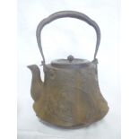 A 19th Century Eastern cast iron tea kettle with raised figure and landscape decoration