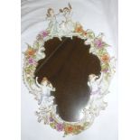 A good quality 20th Century German porcelain oval mirror decorated in relief with numerous cherub