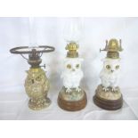 Three various Continental china oil lamps in the form of owls with brass mounts