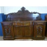 A large Victorian carved mahogany sideboard with serpentine fronted central drawer above cupboard