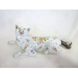 A French Quimper-style pottery figure of a recumbent cat with floral decoration,