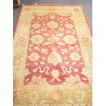A good quality figured wool rug with floral and geometric decoration on red and cream ground 110" x