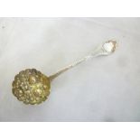 A George IV silver sifting spoon, the scallop bowl with raised floral and fruit decoration,