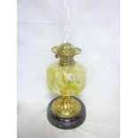 A Victorian brass oil lamp with mottled glass reservoir on ceramic base
