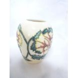 A small Moorcroft pottery tapered vase with floral decoration on cream ground,