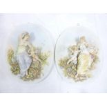 A pair of good quality Continental porcelain oval plaques decorated in relief with females and