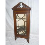 A late Victorian mahogany hanging corner cupboard with shelves enclosed by an astragal glazed door