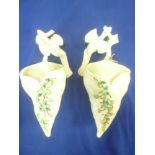 A pair of Continental china leaf-shaped wall pockets with raised floral decoration and bird finials