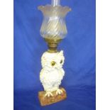 An unusual German china oil lamp in the form of an owl on a branch with glass eyes,