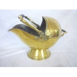 A Victorian brass coal helmet with swing handle on pedestal base