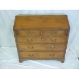 A George III oak bureau with fitted interior enclosed a fall front above two short and three long