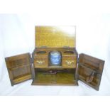 An Edwardian carved oak smoker's cabinet with fitted interior and a ceramic tobacco jar enclosed by