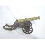 A brass table cannon with 11" tapered barrel on ornamental iron carriage