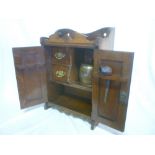 An Edwardian carved oak smoker's cabinet with fitted interior together with matching tobacco jar