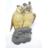 A large pottery figure of two owls perched on a tree stump,