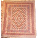 An Eastern hand knotted wool rug with geometric decoration on red ground 53" x 44"