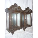 A pair of ornate late Victorian mahogany wall mounted display cabinets with mirrored backs and