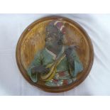 A Continental pottery circular wall plaque depicting a North African musician,
