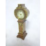 A miniature long-case style mantel clock with decorated circular dial in brass mounted walnut case