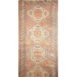 A 19th Century Eastern hand-knotted wool runner with geometric decoration on a red ground: 150" x